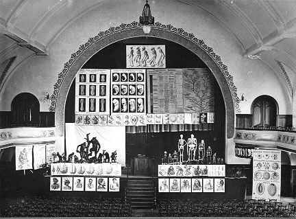 Vortrag Ernst Haeckels (1834–1919) im "Volkshaus" in Jena über die Abstammung des Menschen; Schwarz-Weiß-Photographie, unbekannter Photograph, 1907; Bildquelle: © Ernst-Haeckel-Haus, Jena, http://www.ehh.uni-jena.de/.