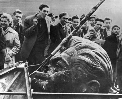 Unknown photographer, Man spitting on decapitated head of Stalin statue, Hungary 1956, black-and-white photograph. Source: libcom.org, https://libcom.org/library/hungary-1956-reading-guide. Creative Commons Attribution-NonCommercial-ShareAlike 2.5 License.